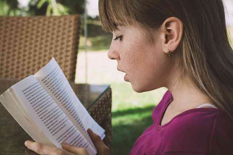 Fille qui lit un livre pour montrer les conséquences de la dyslexie afin de mieux comprendre la dyslexie